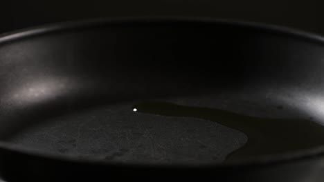 adding an oil on black pan close-up. chef going to cook food on a boiling pan for frying some dishes high quality 4k footage