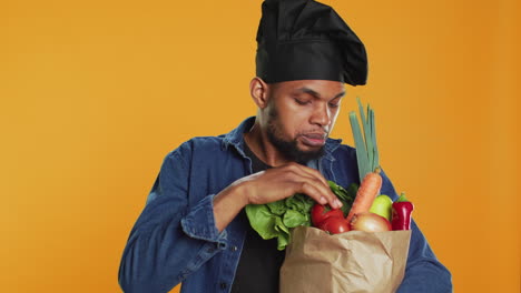 african american cook examining his groceries in a paper bag