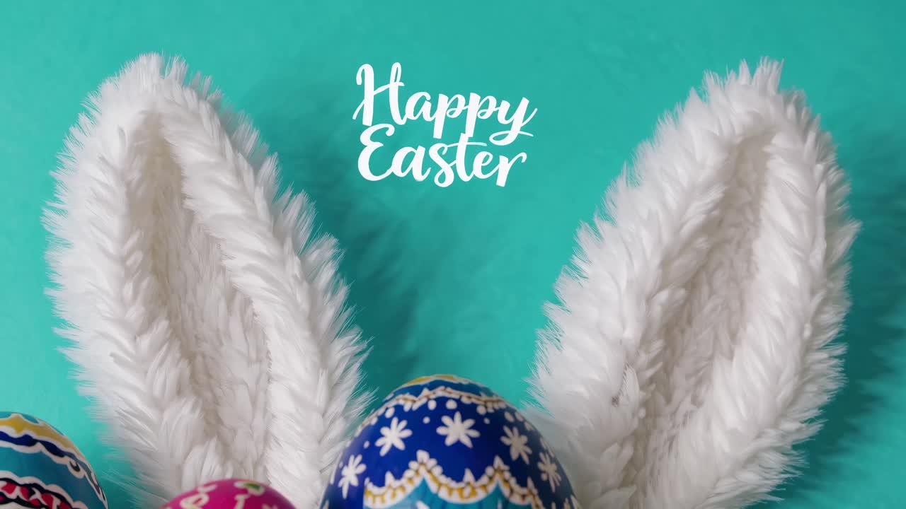 Close-up, top-down angle of fluffy bunny ears against a teal background with 'Happy Easter' text