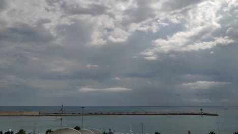 Time-lapse-of-Barcelona's-port-horizon-on-a-bright-day-some-clouds-and-the-sun-shinning-behind