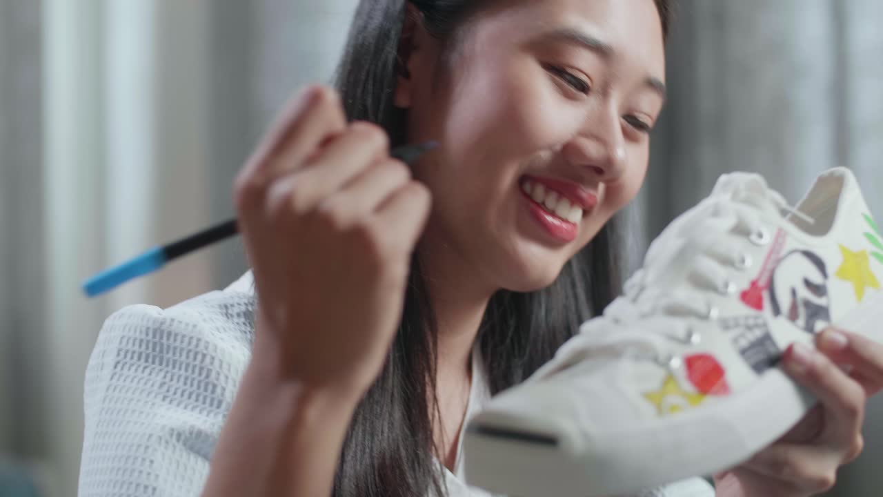 신발 에 장식적 인 디자인 을 그리는 여자