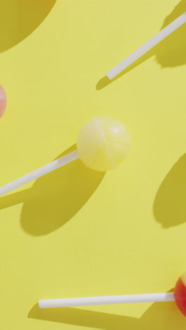 video of multicoloured lollipops on yellow background