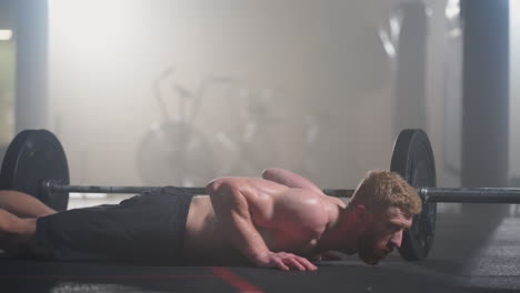 man doing burpee workout at fitness studio. high-intensity interval training. young man practicing burpee exercise