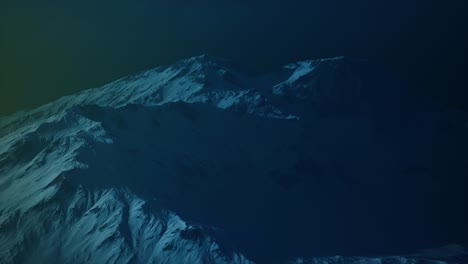 dramatic dark rocky mountain with patches of snow in storm