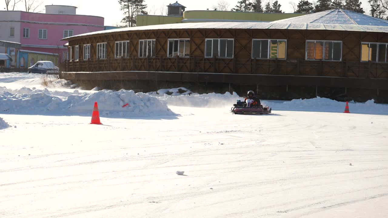 아이 들 이 눈 위 에서 고카르트 를 타고 있다