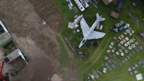 top down aerial view above hawker hunter jet renovation surrounded by parts on gloucestershire farmland