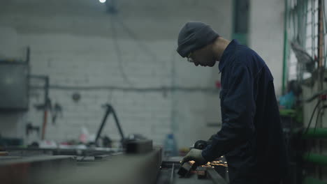 sparks fly from hot metal. man hard worked over the steel. manufacture of railcar or carriage train wagon production factory workers are welding in protective helmets and glasses.