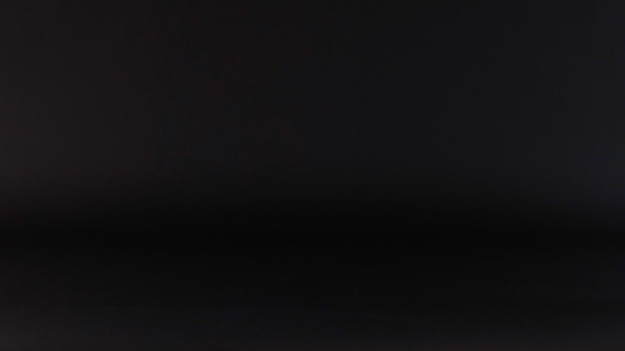 una pelota de tenis azul rebota en la oscuridad