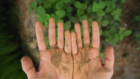 slow motion hands holding organic soil in nature