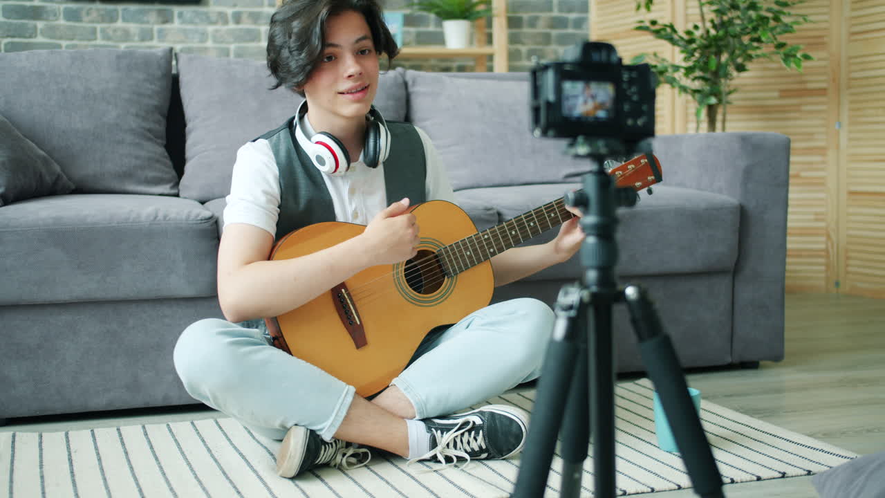 Teenager playing guitar for a video tutorial