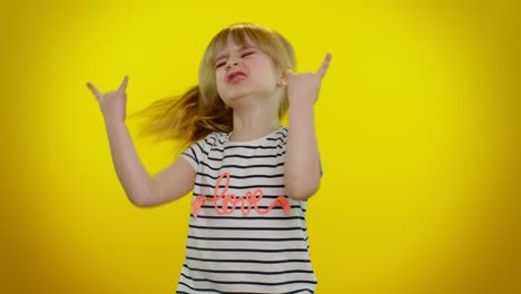 overjoyed kid showing rock n roll gesture by hands, cool sign, dancing rejoicing in success win