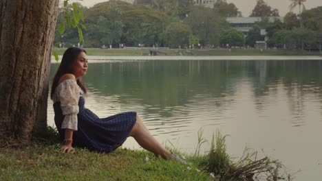 woman relaxing by the lake in a park