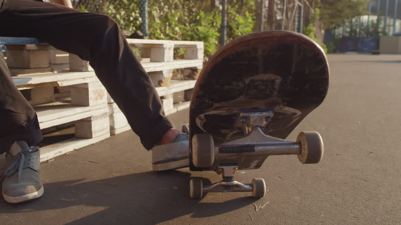 Teenager with Skateboard Browsing Internet on Mobile Phone