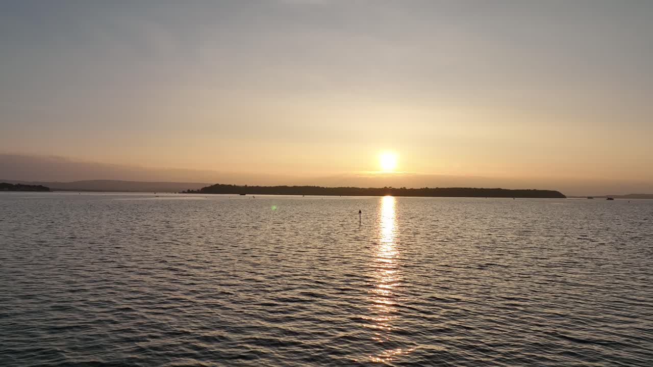 bournemouth, reino unido - volando hacia el océano con un barco que pasa recortado en la puesta de sol