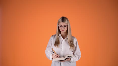 young woman student reading and writing notes in a book