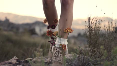 mujer está caminando con botas decoradas artificialmente con flores