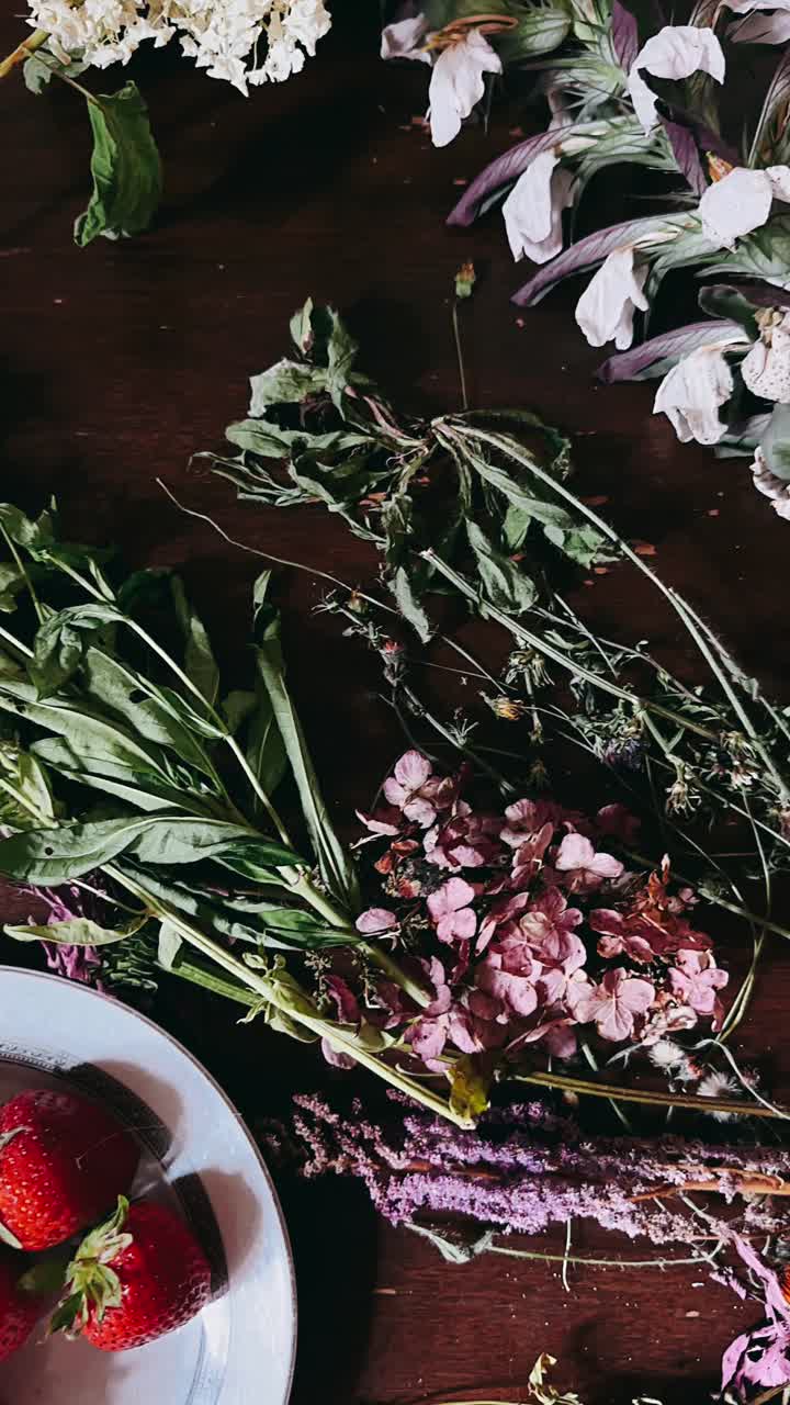 어두운 나무 테이블 에 말린 꽃 과 딸기