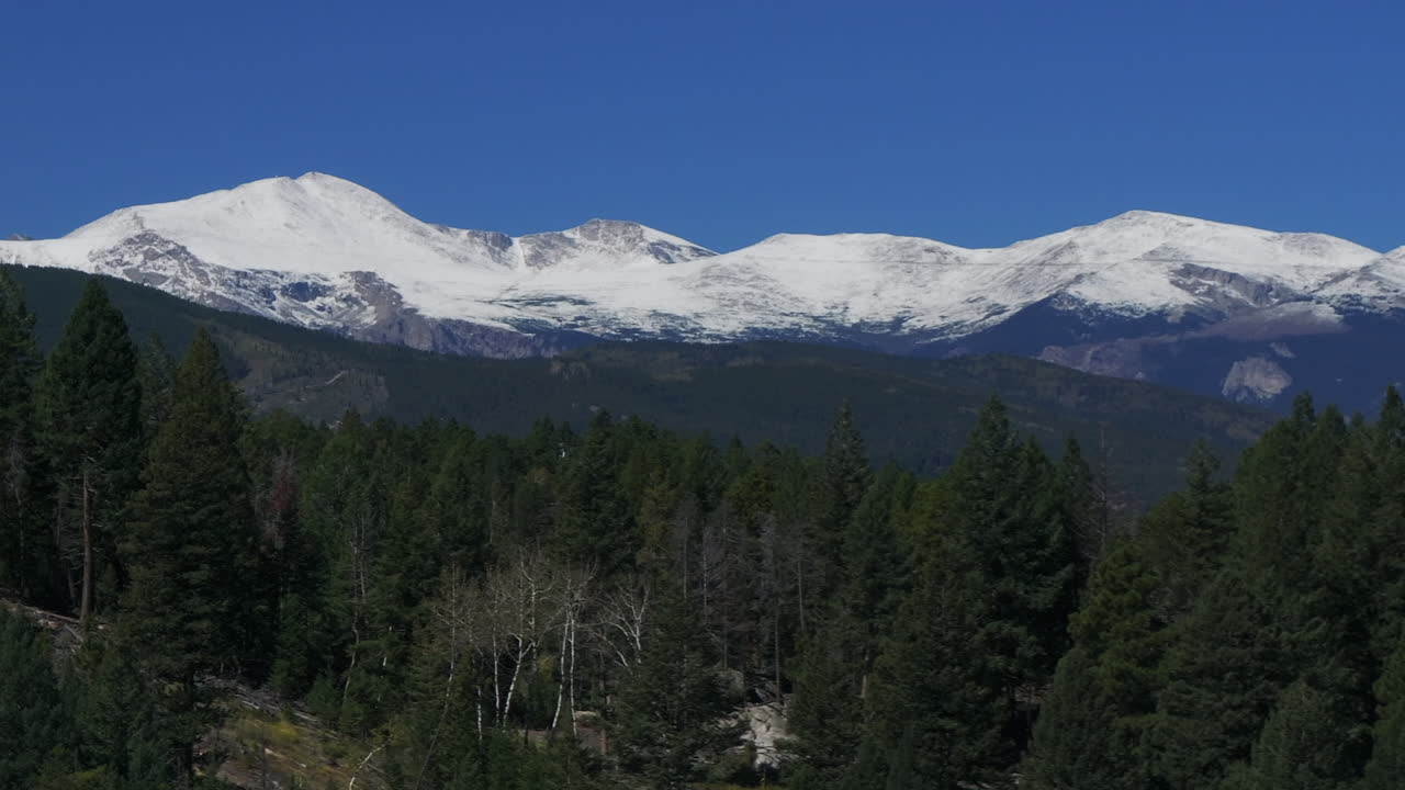 Zoom aereo cinematografico con drone sulla prima neve del Monte Denver Blue Sky Evans, vetta 14er, all'inizio dell'autunno. Splendida mattinata limpida e serena all'alba sulle Montagne Rocciose del Colorado, con movimento circolare lento verso destra