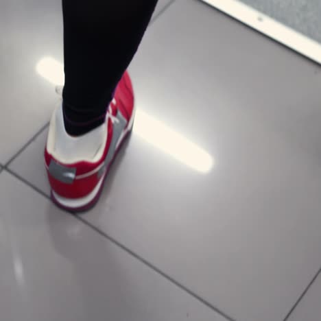 woman walking along the corridor in the gym. female legs close-up in the gym. the ideal female figure