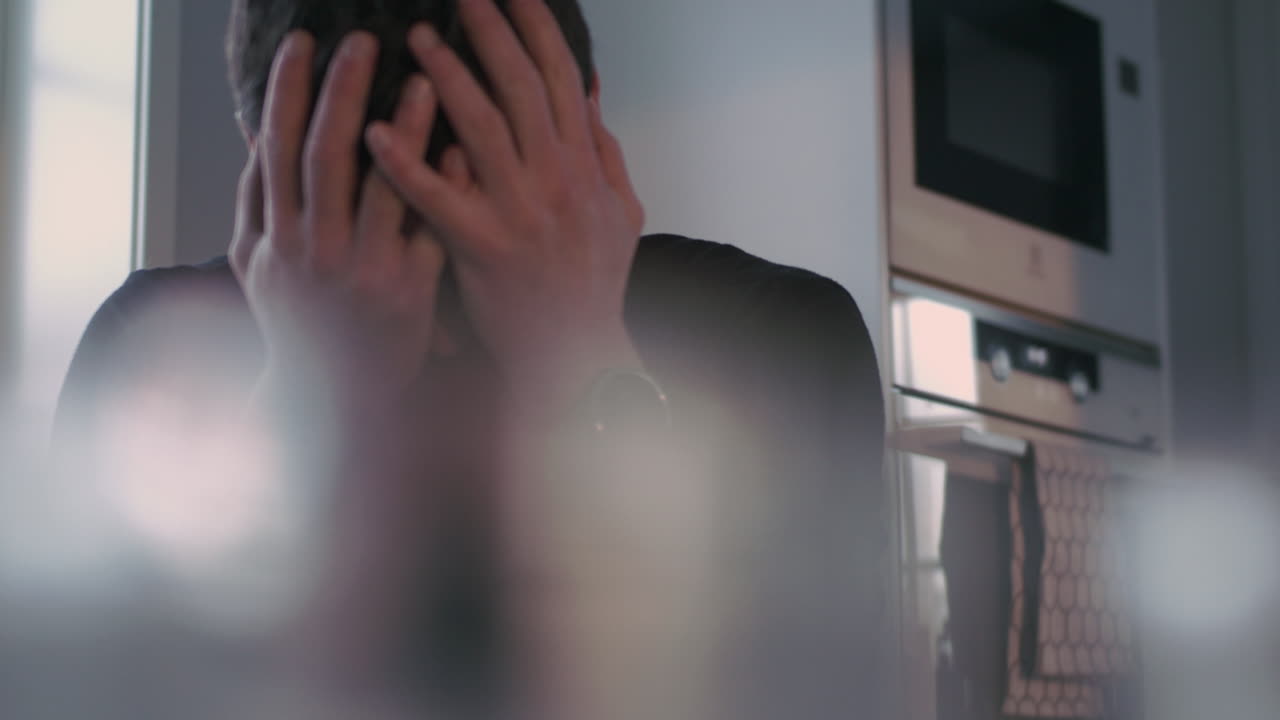 el hombre se frota las manos por el pelo negro con tristeza y desesperación, tiro de muñeca