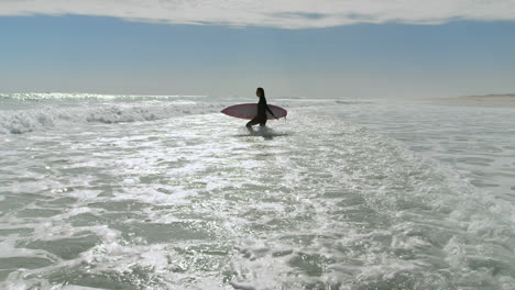 Woman-with-surfboard-running-on-the-sea-4k