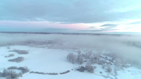 snow covered landscape, forest shrouded in fog, winter season in norway - aerial dolly shot