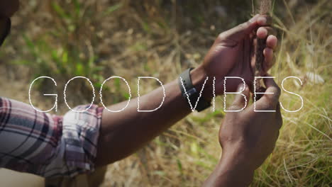 animation of the words good vibes written in white over man in nature holding tall grass stem