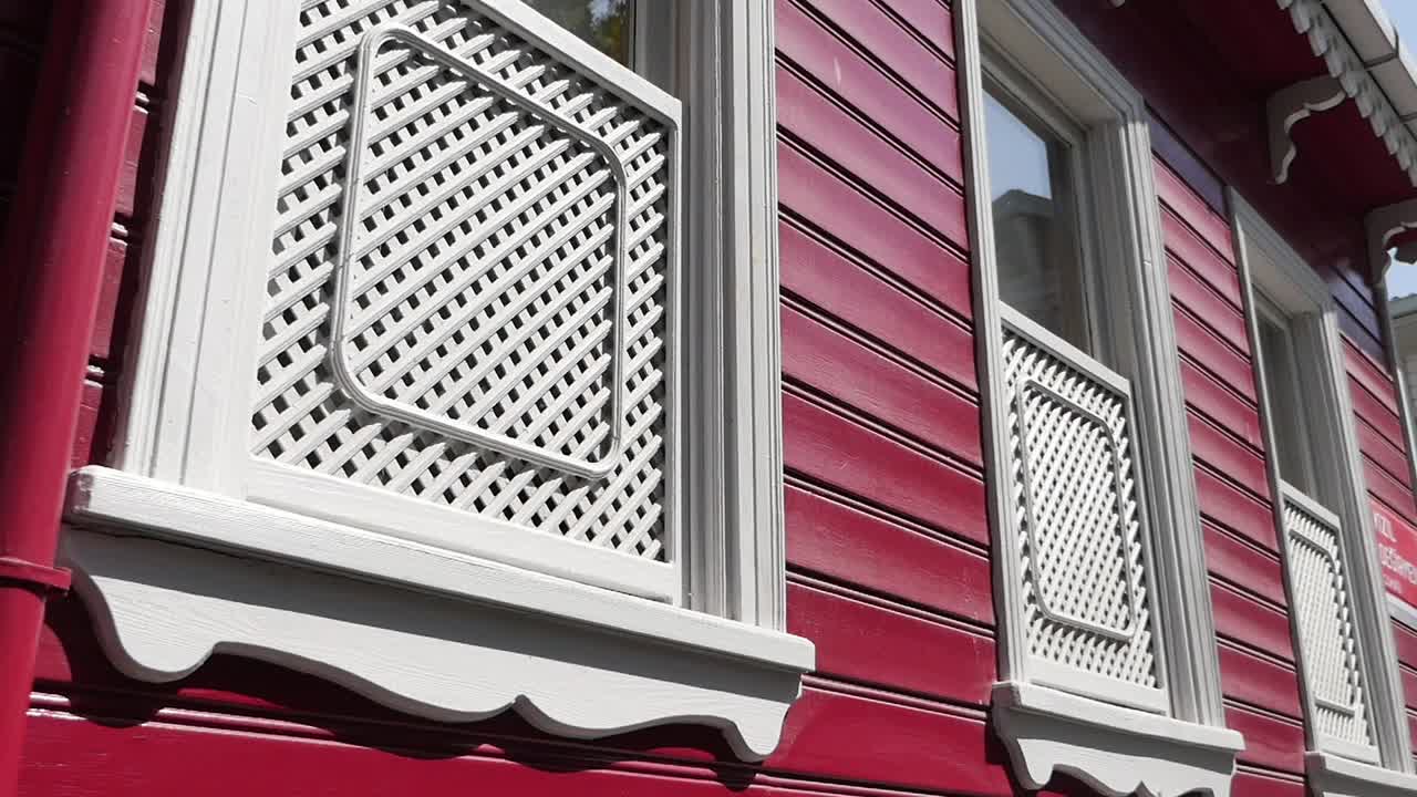 casa de madera roja con adornos y ventanas blancas