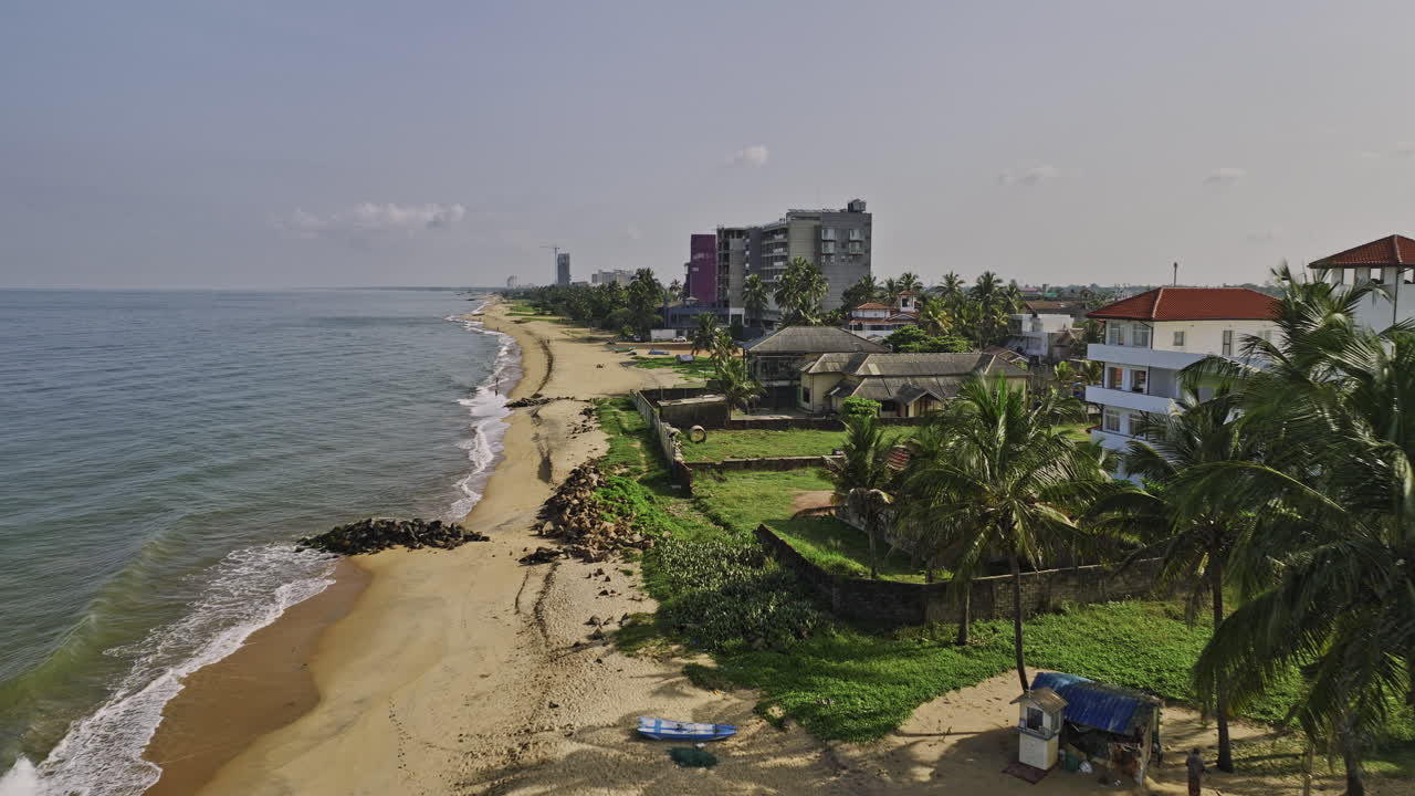 negombo sri lanka aerial v11 cinematográfico drones sobrevuelan hoteles a lo largo de la playa de wellaweediya hacia el vecindario residencial capturando la playa de arena dorada en un día soleado - filmado con mavic 3 cine - abril 2023