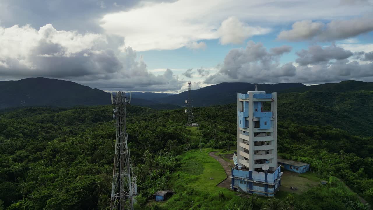 Aerial drone shot of PAGASA Weather Radar Station at lush tropical island with mountainous backdrop - Buenavista, Catanduanes, Philippines