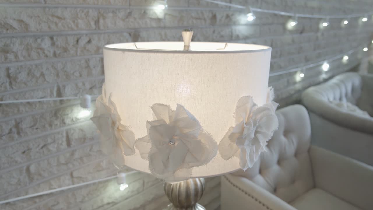 una lámpara blanca junto a una pared de ladrillos blancos con luces blancas y sillas blancas