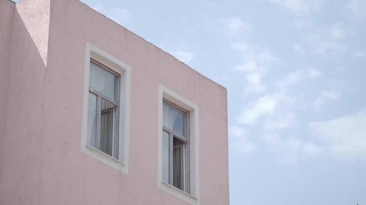 Edificio rosa con finestre su un cielo blu