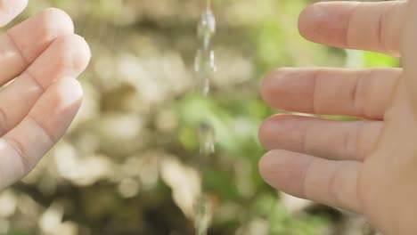 Pale-light-skinned-hands-cupping-under-running-water-to-save-some-in-slow-motion