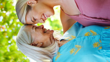 Vertikales-Video-Einer-Mehrgenerationenfamilie-Mit-älterer-Mutter-Und-Erwachsener-Tochter,-Die-Im-Garten-Lachen