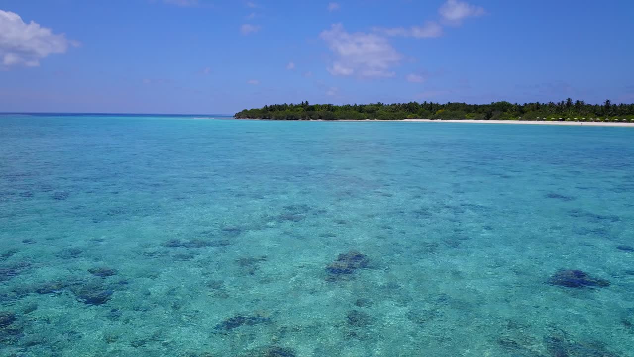 alejar las aguas turquesas del mar caribe con playas blancas cubiertas de palmeras a lo lejos, imágenes de drones de baja altitud a la luz del día