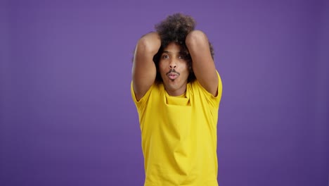 man with afro hair reacts with shock and surprise on purple background