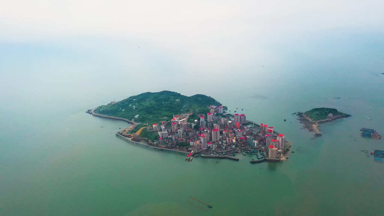 Aerial perspective of Gaobei Island, Putian City, in Fujian Province, China. The island’s dense urban area contrasts with its surrounding greenery and tranquil ocean waters.