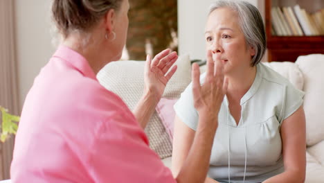 caucasian and asian women engaged in a conversation at home