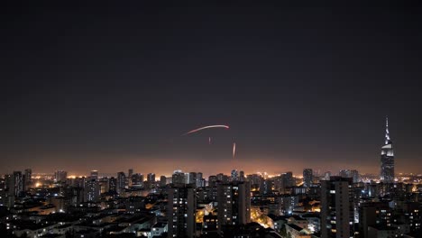 fireworks bursting over a modern city skyline, lighting up the night sky and creating a lively, festive ambiance filled with colorful explosions and shimmering lights