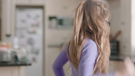 happy ballerina girl dancing in kitchen wearing purple tutu having fun performing funny dance moves enjoying weekend celebration at home