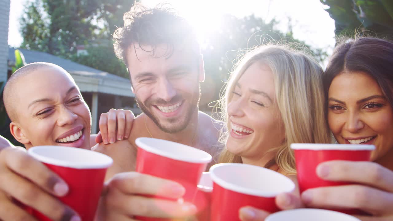 grupo de amigos con bebidas al aire libre relajándose en la piscina y disfrutando de la fiesta de la piscina de verano