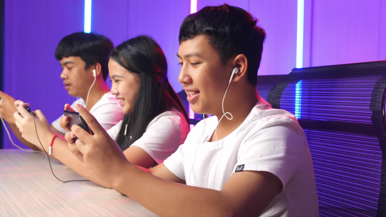 Team Of Asian Esport Gamers Playing In Competitive Video Games On A Cyber Games Tournament By Mobile Phone