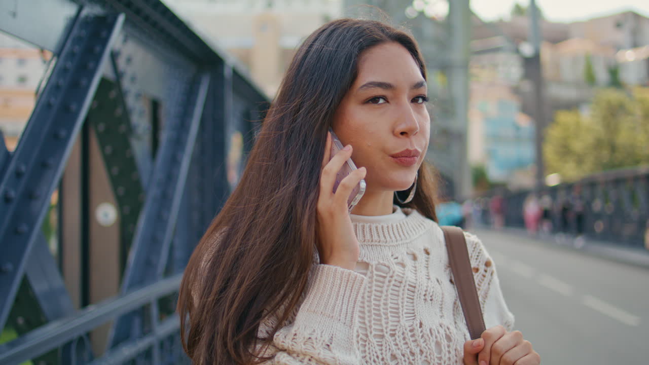 Serious model speaking call using mobile phone on street closeup. Woman talking