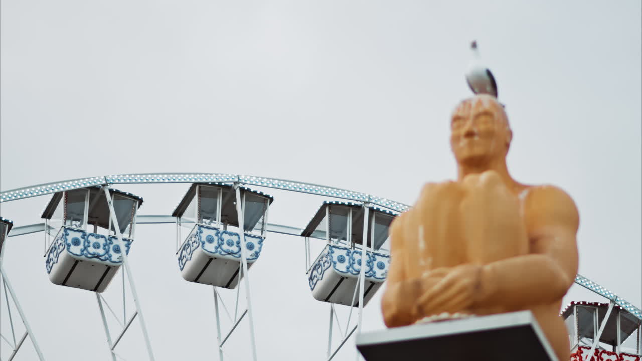 Nice, France - December 8, 2024: Conversation a Nice statue by Jaume Plensa at Place Massena with a ferris wheel on the background