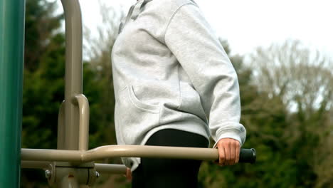 fit woman exercising on outdoor machine