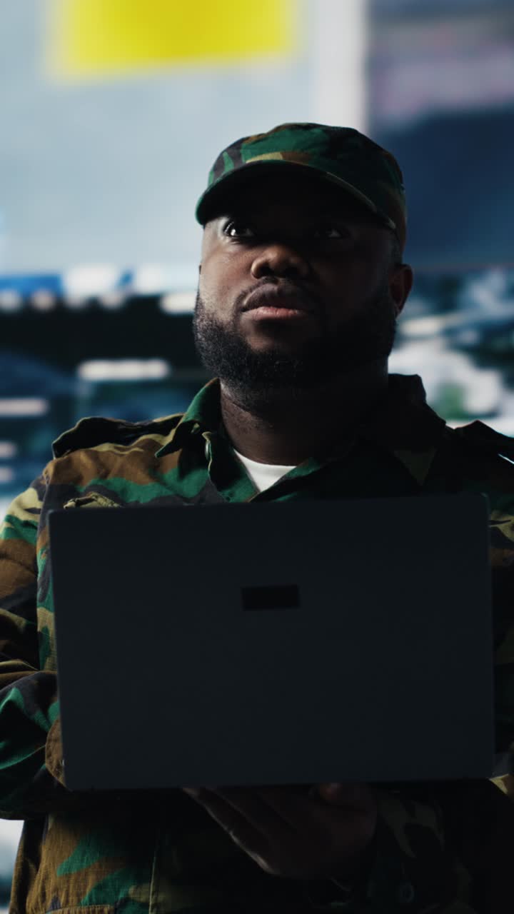 Fokuseret soldat i camouflageuniform arbejder på bærbar computer
