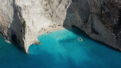 small cove beach with calm blue sea near navagio beach in zakynthos, ionian islands of greece