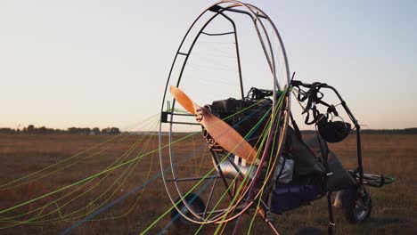 piloto masculino de un planeador de motor fija el paracaídas en el cuerpo del planeador en preparación para el vuelo y comprobando el equipo. extender el paracaídas