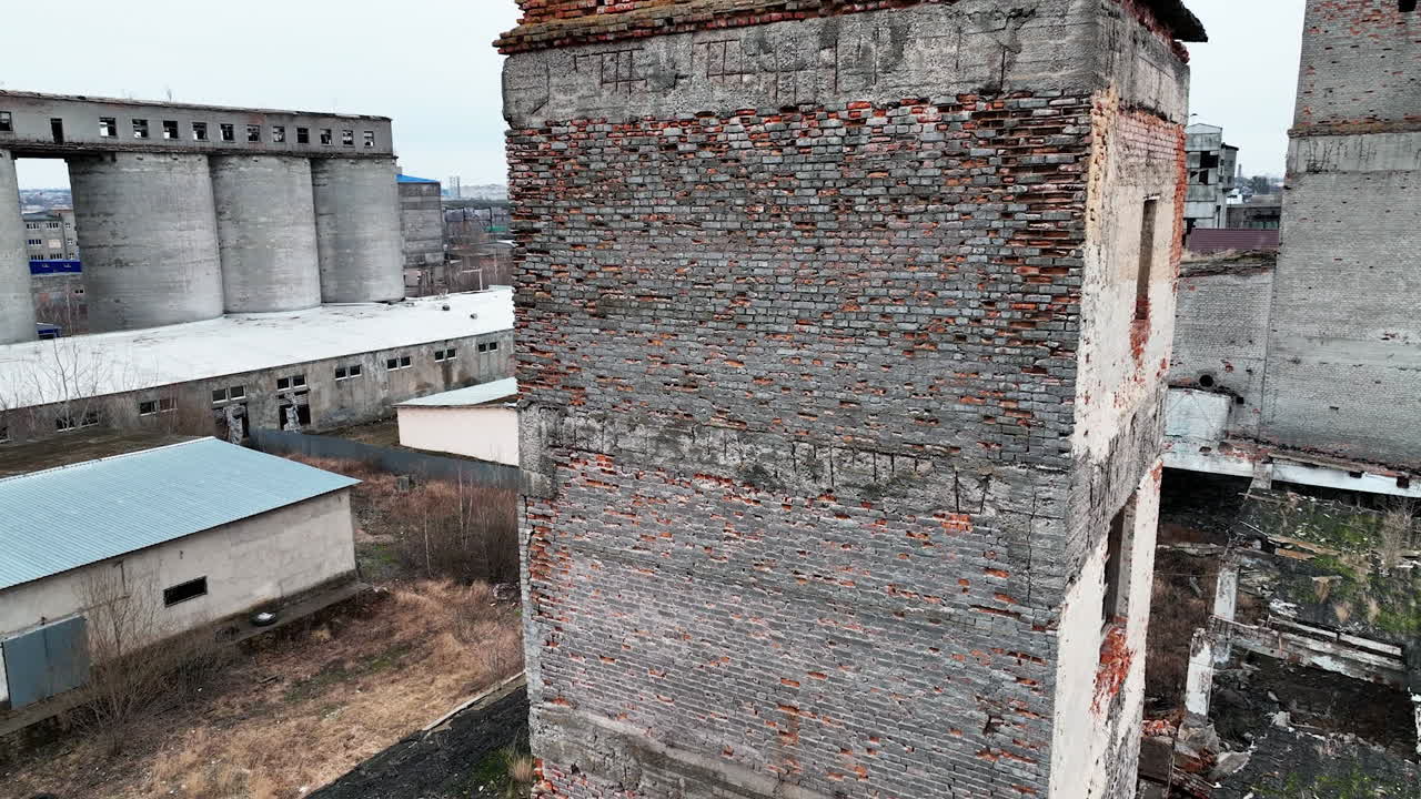 Decayed territory of an old factory. Warehouses that are no longer in use. Cityscape at the backdrop.