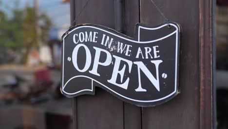 open sign hanging on wooden door